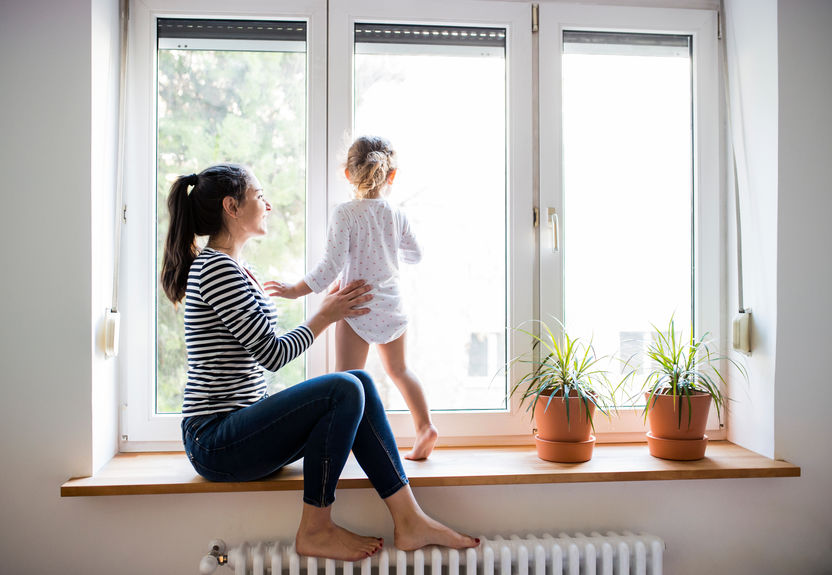 image of woman playing with her toddler in a sitting window sill